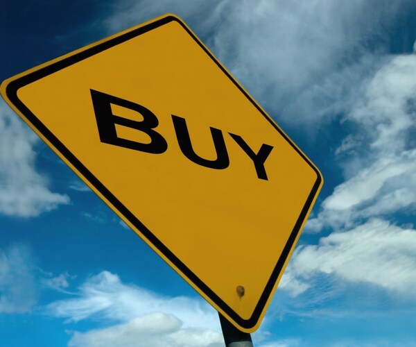 yellow diamond sign with buy written in capital black letters amid blue sky