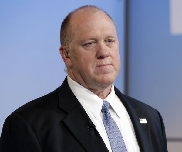 tom homan is shown stands expressionless awaiting an interview