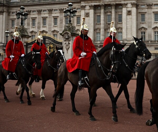 Horses ridden by men wearing red jackets