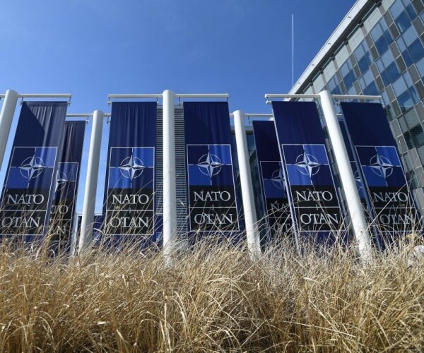 banners with the nato logo are pictured in front of the new nato headquarters