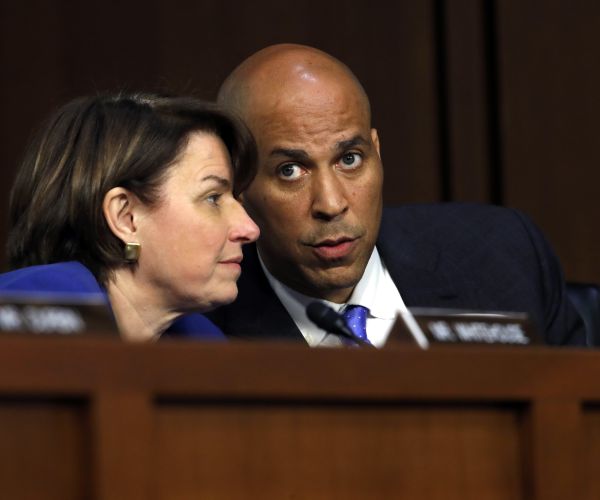 sen. amy klobuchar, left, listens to sen. cory booker as they attend the confirmation hearing of brett kavanaugh. 