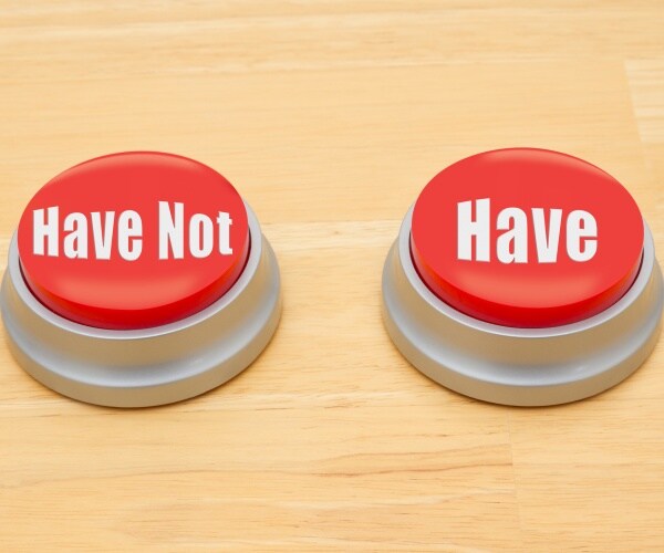two red and silver push button on a wooden desk with text have not and have
