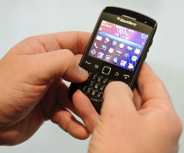 a person's hands using a blackberry device