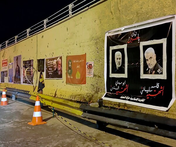 posters line a wall near the site of where iranian general qassem soleimani was killed in Baghdad