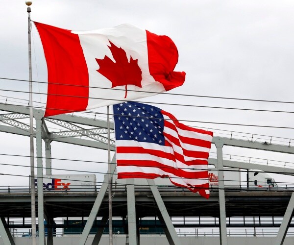 canadian and us flags are shown together near the us canada border