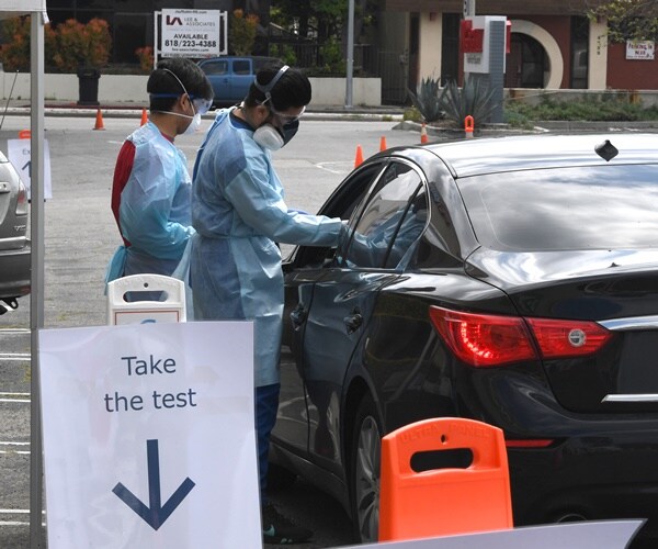 healthcare workers in protective gear test residents in their cars