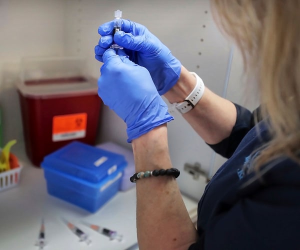 a health worker in tennessee prepares a flu vaccine