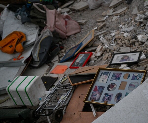 family photos and personal items are scattered amongst the rumble of a destroyed house near the border with gaza