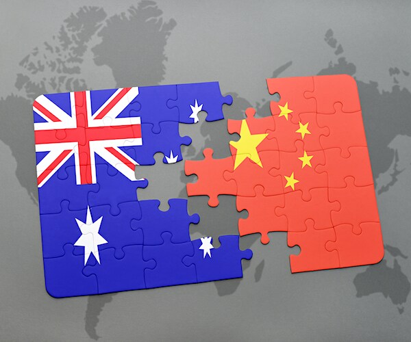an australia and a china flag in an interlocking puzzle graphic laid over a world map