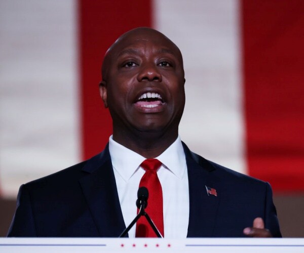 US Sen. Tim Scott stands on stage delivering speech
