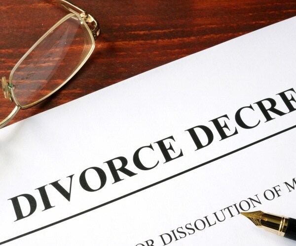 divorce decree printed on copy paper with a pen and glasses