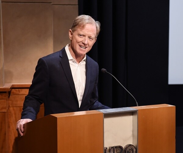 redford in a suit speaking at a podium at an hbo event