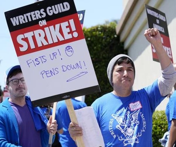 writers guild protester holds sign