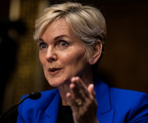 granholm in a cobalt blue blazer and black top