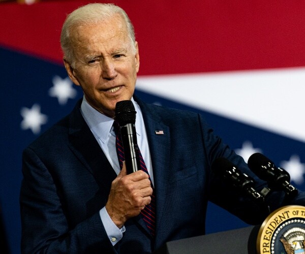 joe biden speaks into a microphone