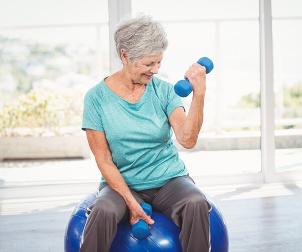 a senior woman lifting weights in her home