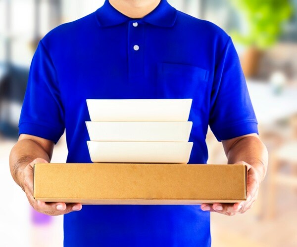 food delivery service or order food online. delivery man in blue uniform with hand holding food packaging 