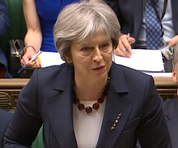 british prime minister theresa may stands and looks slightly to her left as she speaks to parliament