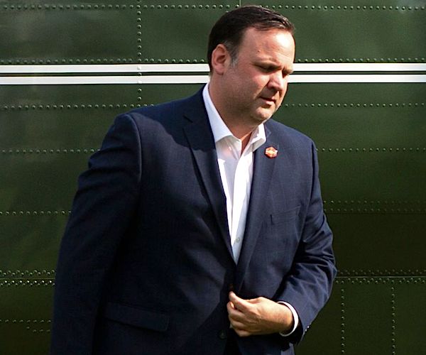 White House aide Dan Scavino buttons his jacket after walking out of marine one
