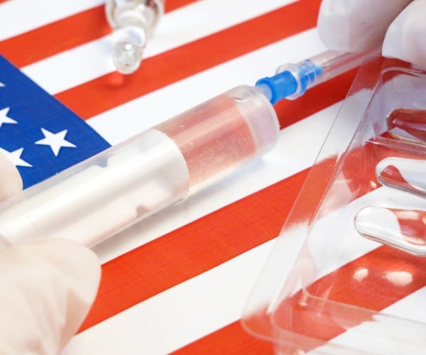 a syringe over a u.s. flag