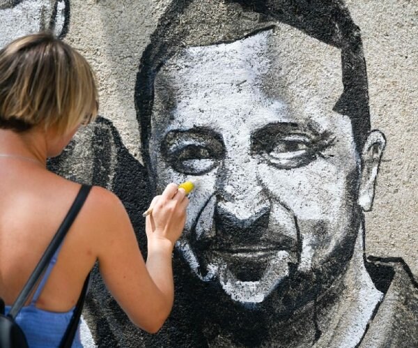 an artist paints a mural of ukraine president volodymyr zelenskyy