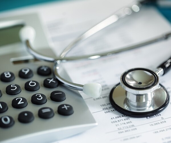 calculator and stethoscope on financial statement concept for finance health check or cost of healthcare