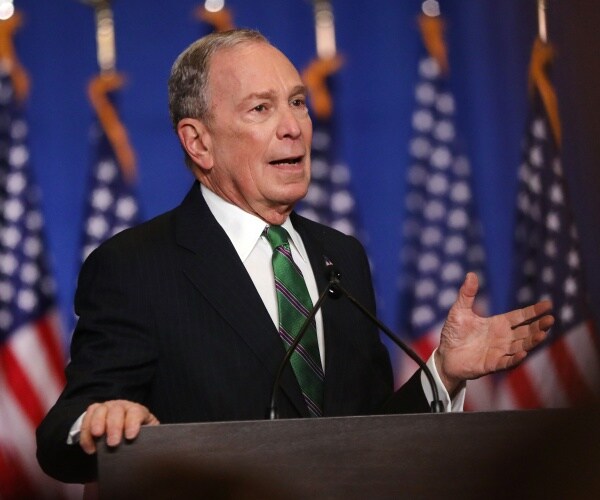 bloomberg in a suit and green tie  speaking at the democrat convention