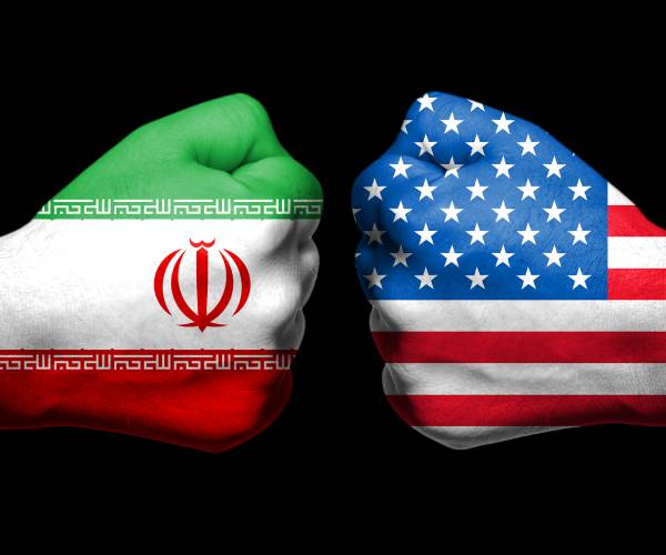 two fists facing each other with flags of iran and united states painted on them