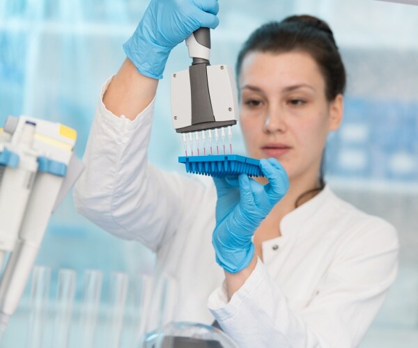 scientist in lab conducting genetic blood tests