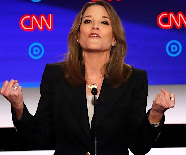 Marianne Williamson clenches her fist and looks up into the air during the second democratic primary debate