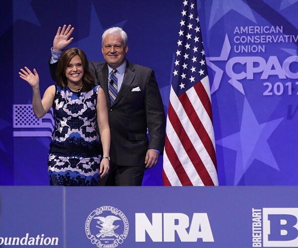 matt and mercedes schlapp wave to the audience from the stage of cpac
