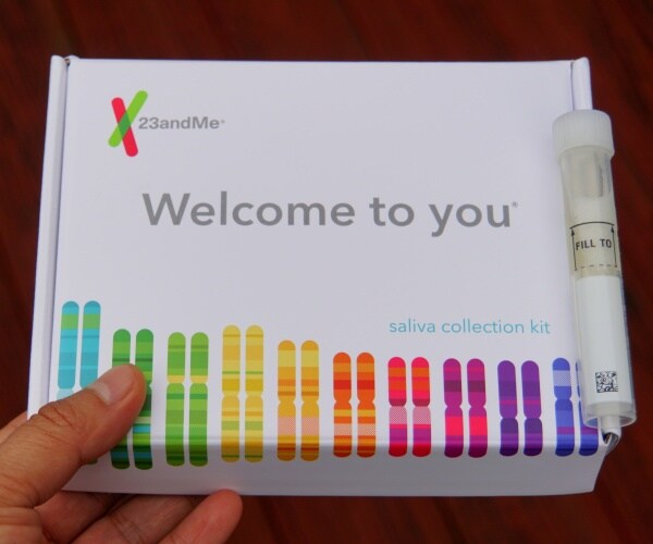 23andme kit is shown with a saliva sample container 