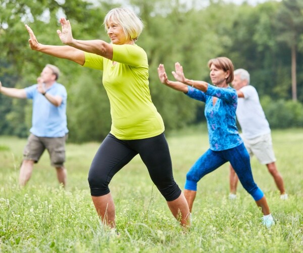 older adults doing tai chi in field