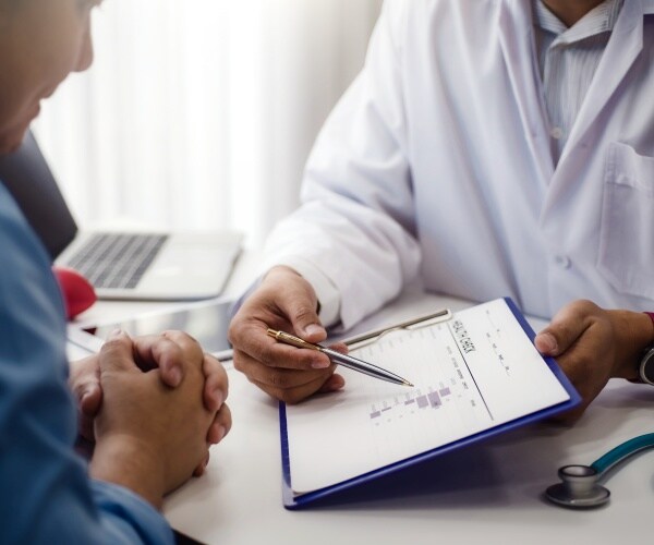 Doctor reviewing test results with male patient