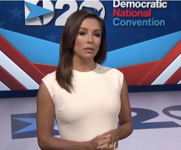 eva longoria in front of a screeen reading democratic national convention