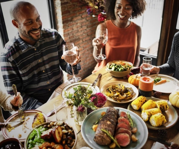 people sit at the dinner table and celebrate thanksgiving