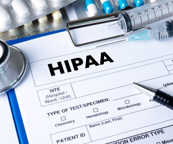 a hipaa form with a pen, stethoscope and pills