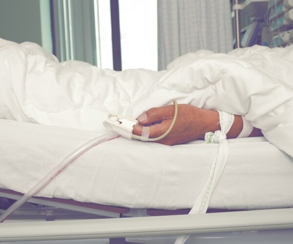 arm of sick patient in hospital bed