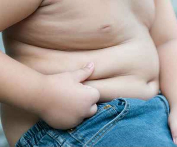 a sitting obese child is shown from a side angle from the waist down