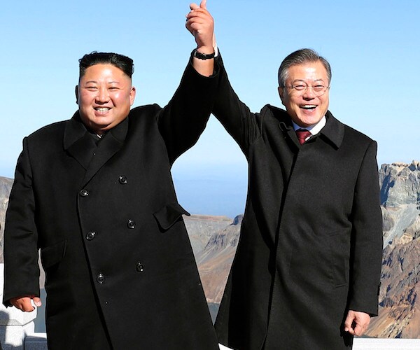 North Korea's Kim Jong Un and South Korea's Moon Jae-in hold up each others hands in a photo op