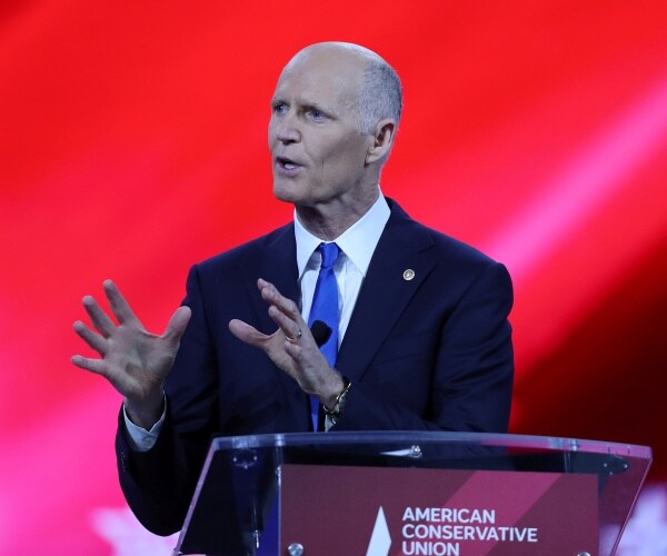 rick scott speaks on a stage