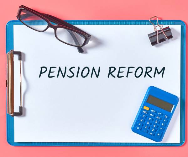 a clipboard with pension reform written on it surrounded by a calculator and other items