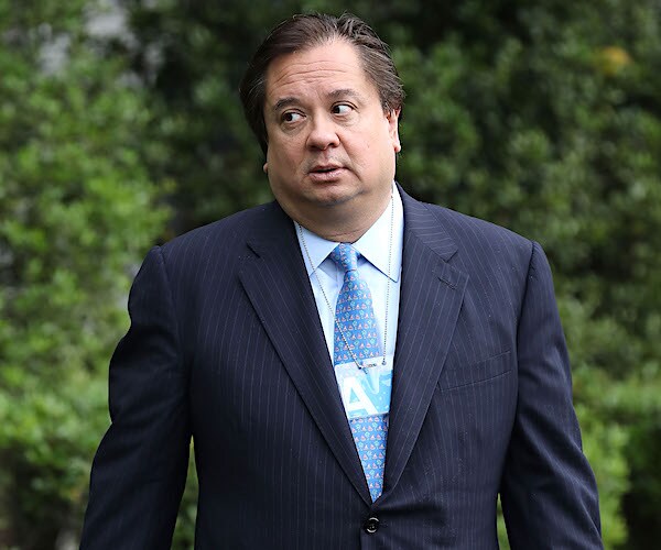george conway stands and fish eyes something to his right