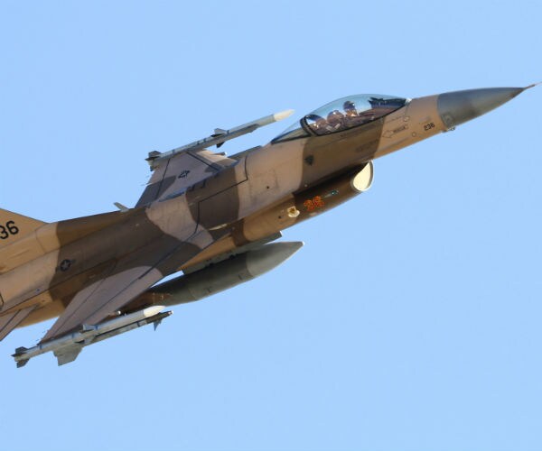 an air force f-16 fighter jet is shown ascending into the sky