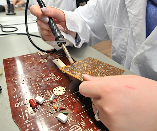 students of vocational school in a workshop of electrical engineering study and soldering of simple electric circuits