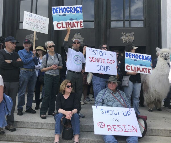 people on the capitol steps holding protest signs