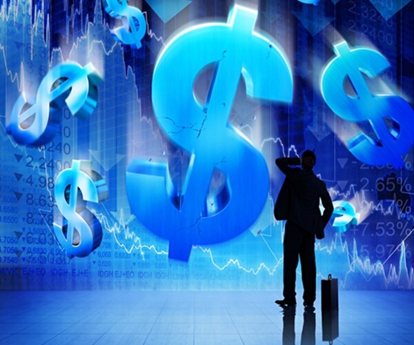 businessman shielding self from falling dollar signs