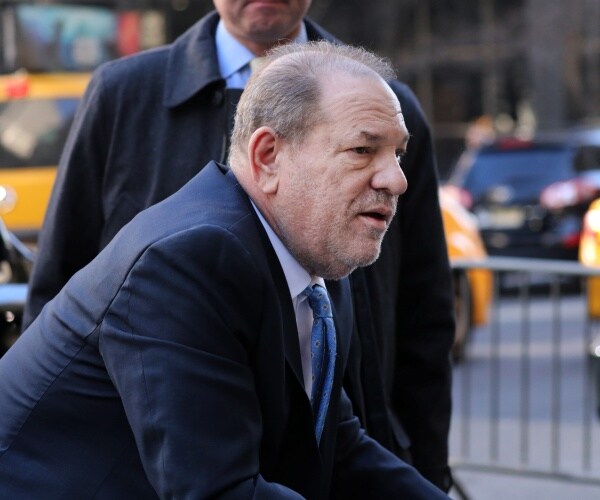 weinstein in a suit and blue tie getting out of the car