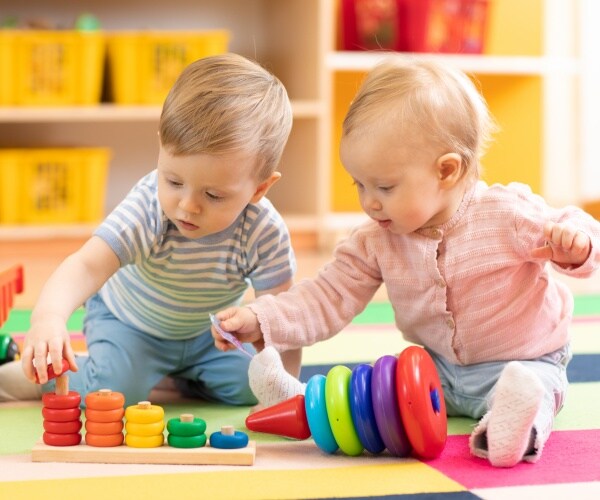 two babies playing with blocks together