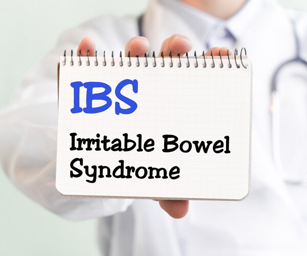 a doctor holding a sign that reads irritable bowel syndrome